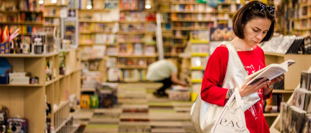 Γυναίκα διαβάζει βιβλίο σε βιβλιοπωλείο