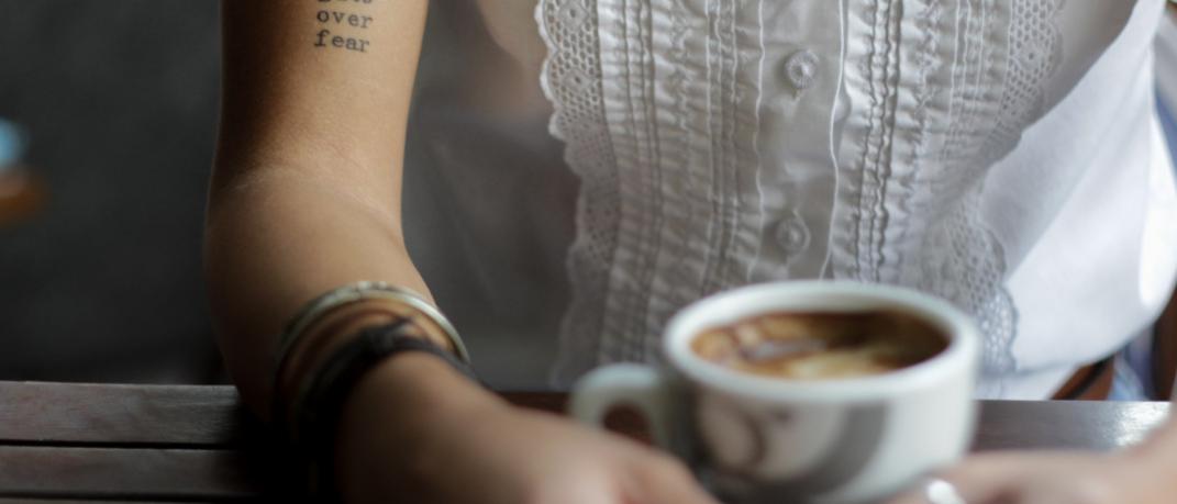 Γυναίκα κρατά κούπα καφέ