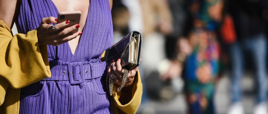 Γυναίκα με ντεκολτέ κρατά τσάντα και κινητό streetstyle