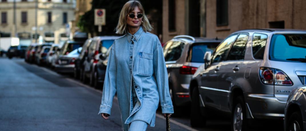 γυναίκα περπατά με τζιν πουκάμισο και παντελόνι στην εβδομάδα μόδας