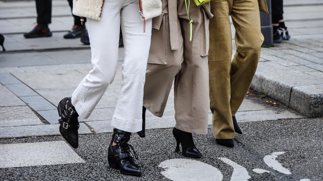 γυναίκες με παντελόνια και μπότες περπατούν στην εβδομάδα μόδας