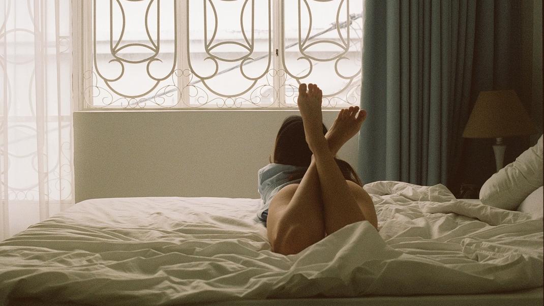 Γυναίκα ξαπλωμένη στο κρεβάτι κάνει sexting
