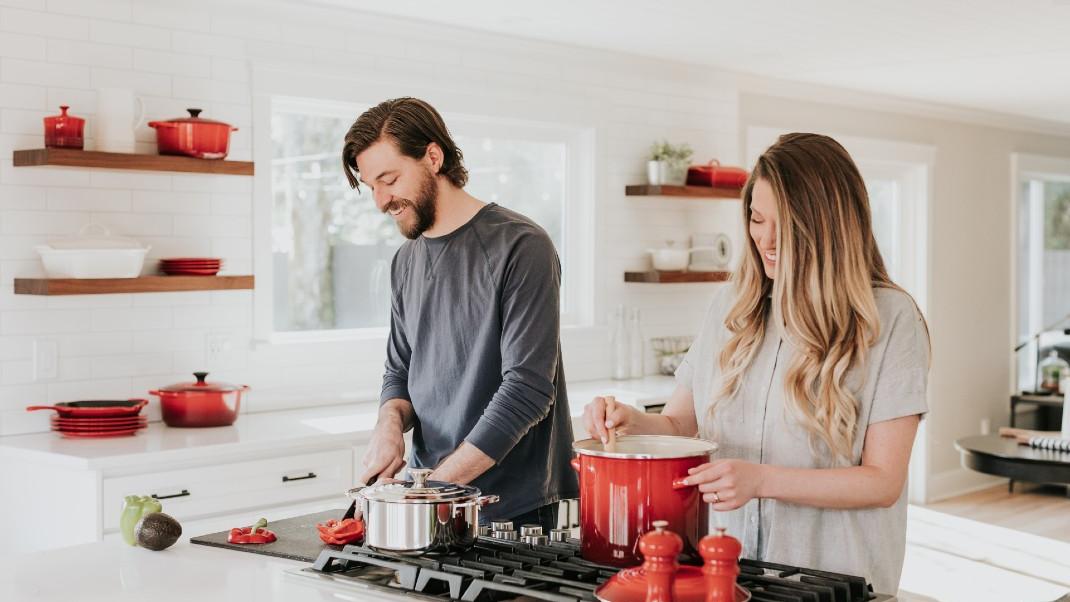 Ένας άντρας και μια γυναίκα μαγειρεύουν μαζί στην κουζίνα