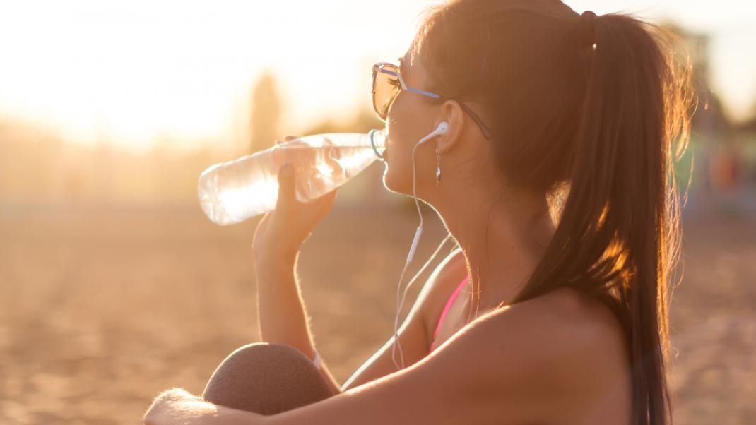 Γυναίκα πίνει νερό στην παραλία, Φωτογραφία: Shutterstock