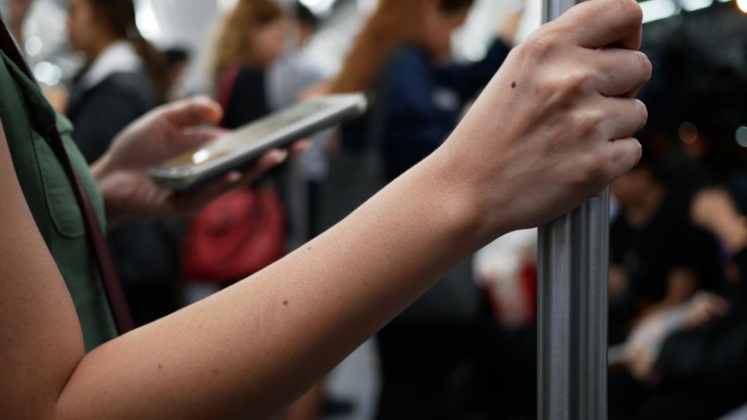 Μια γυναίκα αγγίζει την χειρολαβή στο μετρό, Φωτογραφία: Shutterstock/By chanonnat srisura