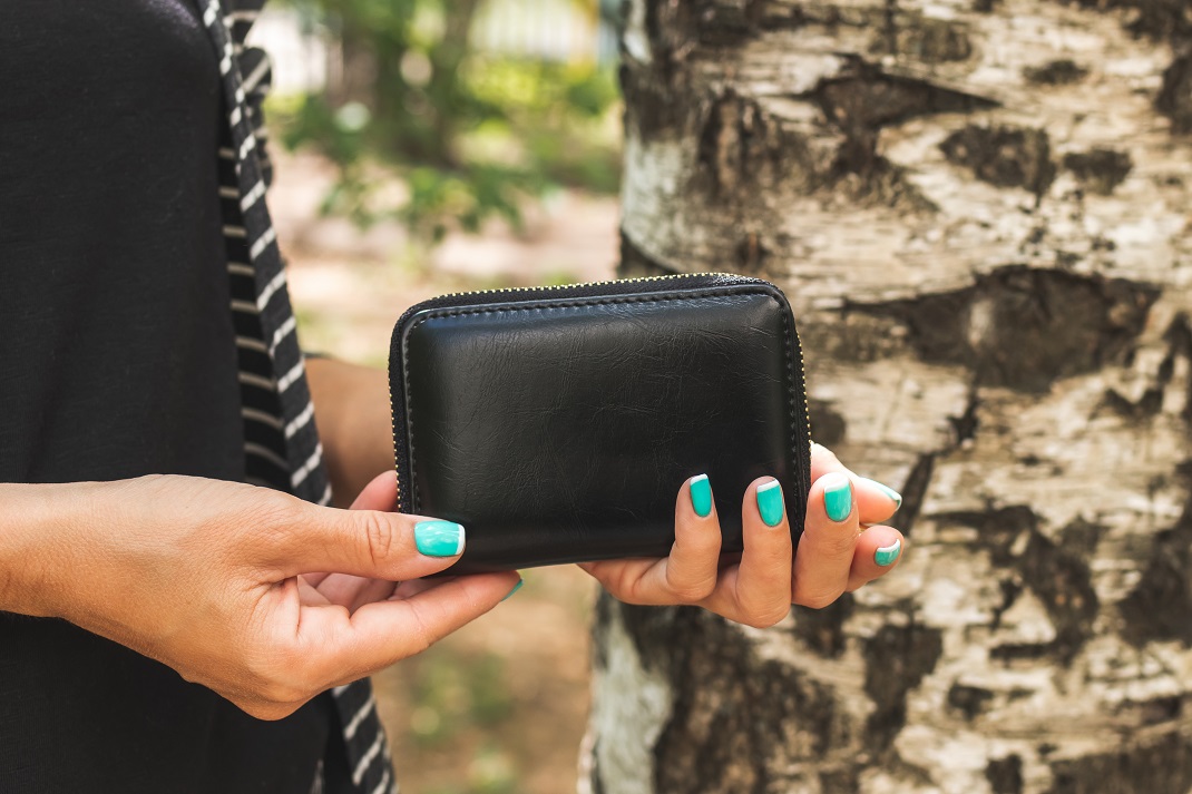 Γυναίκα κρατά πορτοφόλι και κάνει καλύτερη διαχείριση των χρημάτων της