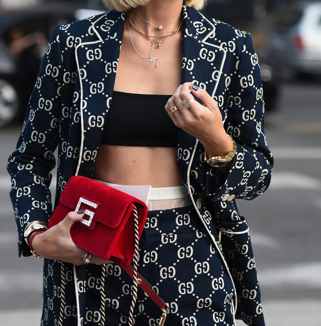 γυναίκα με σακάκι με logo περπατά στην εβδομάδα μόδας