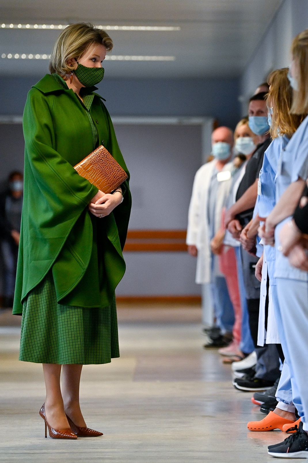 η βασίλισσα Ματθίλδη με μάσκα και πράσινο σύνολο