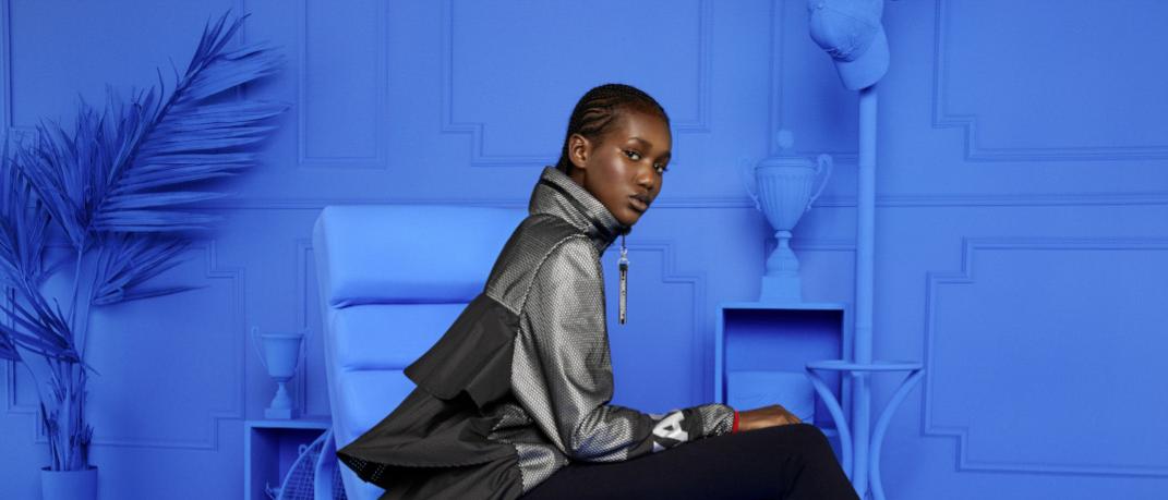 γυναίκα κάθεται σε μπλε δωμάτιο και φορά τη συλλογή Puma X Karl Lagerfeld