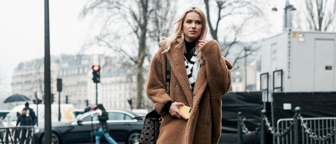 γυναίκα περπατά με παλτό και τσάντα στην εβδομάδα μόδας