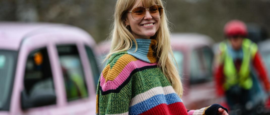 γυναίκα με πλεκτό πουλόβερ με ρίγες και γυαλιά στο δρόμο