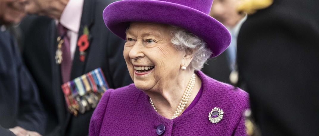 Η βασίλισσα Ελισάβετ με μοβ καπέλο χαμογελά