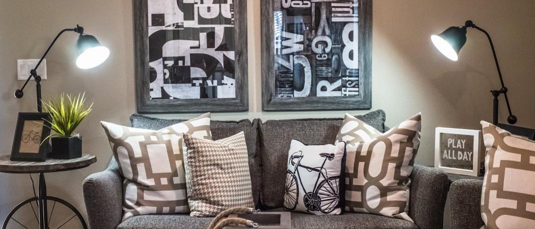 Σαλόνι σε cozy σπίτι με καναπέ, φωτιστικά και πίνακες