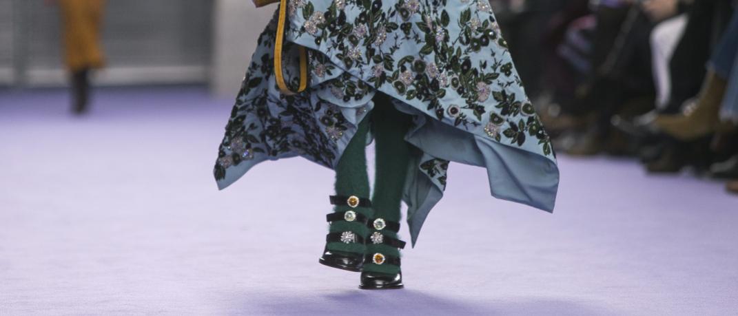 γυναίκα περπατά με πέδιλα και τσάντα σε επίδειξη μόδας
