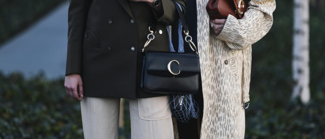 γυναίκες με παλτό και τσάντες στέκονται στο δρόμο στην εβδομάδα μόδας