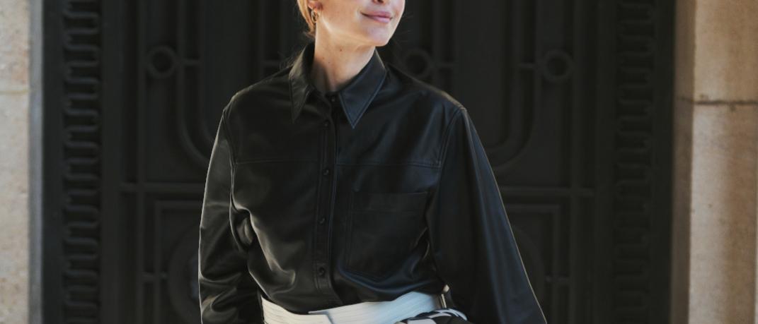 γυναίκα με δερμάτινο πουκάμισο και λευκό παντελόνι στην εβδομάδα μόδας