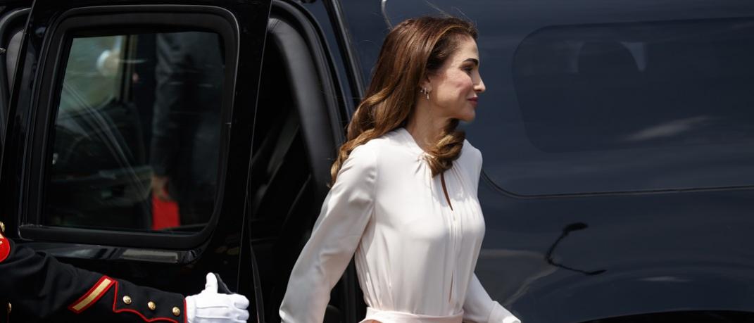Η βασίλισσα Ράνια με λευκό φόρεμα κρατά τσάντα