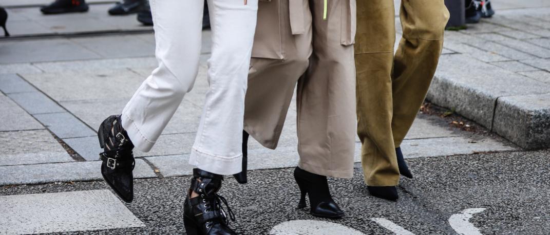 γυναίκες με παντελόνια και μπότες περπατούν στην εβδομάδα μόδας