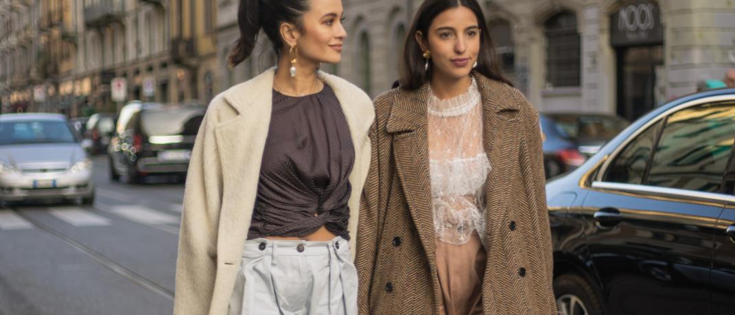γυναίκες με παλτό και τοπ περπατούν στην εβδομάδα μόδας