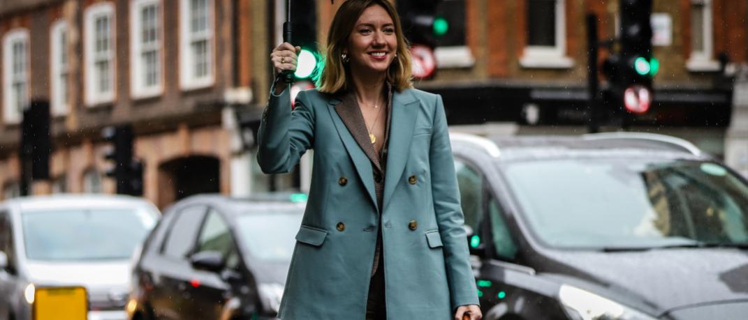 γυναίκα περπατά στην εβδομάδα μόδας με σακάκι και ομπρέλα