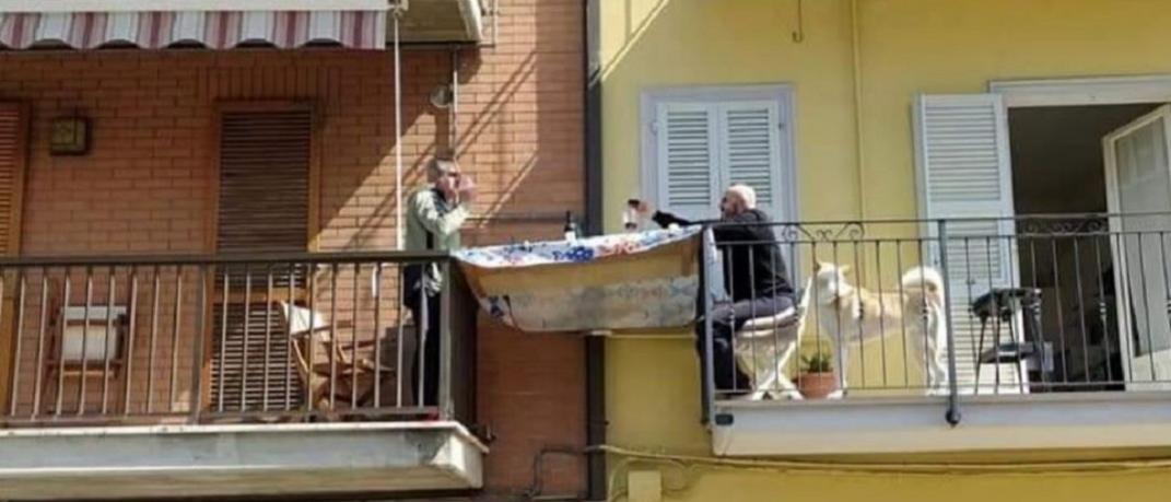 γείτονες τρώνε μαζί από τα μπαλκόνια τους