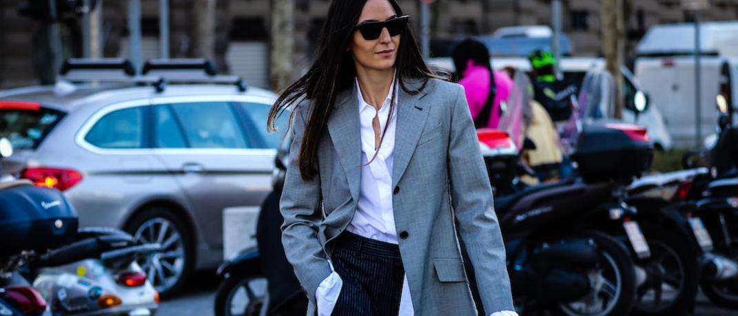 γυναίκα περπατά στην εβδομάδα μόδας με σακάκι και γυαλιά