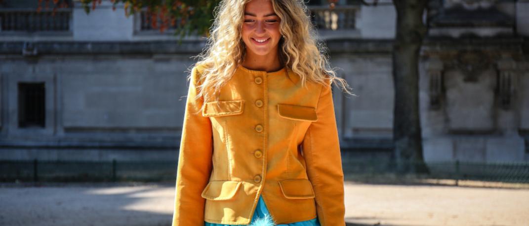 γυναίκα με κίτρινο σακάκι περπατά στην εβδομάδα μόδας