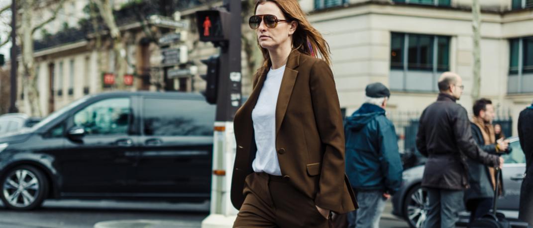 γυναίκα περπατά στο δρόμο με κοστούμι και γυαλιά
