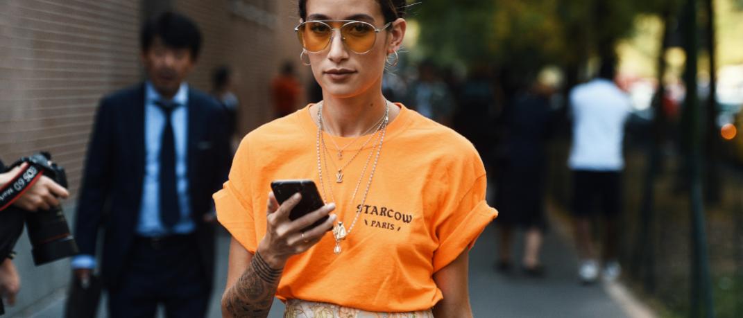 γυναίκα με πορτοκαλί τοπ στην εβδομάδα μόδας