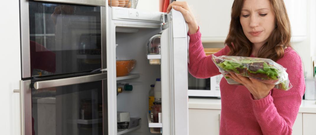 Γυναίκα κοιτάζει τρόφιμα σε ψυγείο