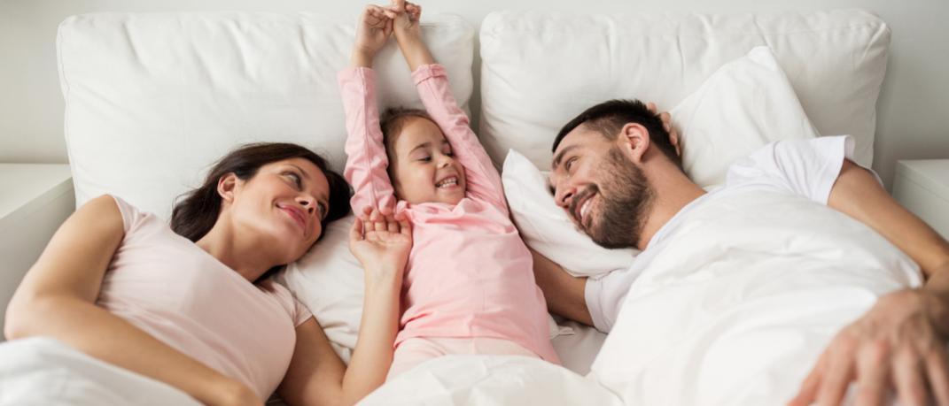 Οικογένεια ξαπλωμένη στο κρεβάτι, Φωτογραφία: Shutterstock/By Syda Productions