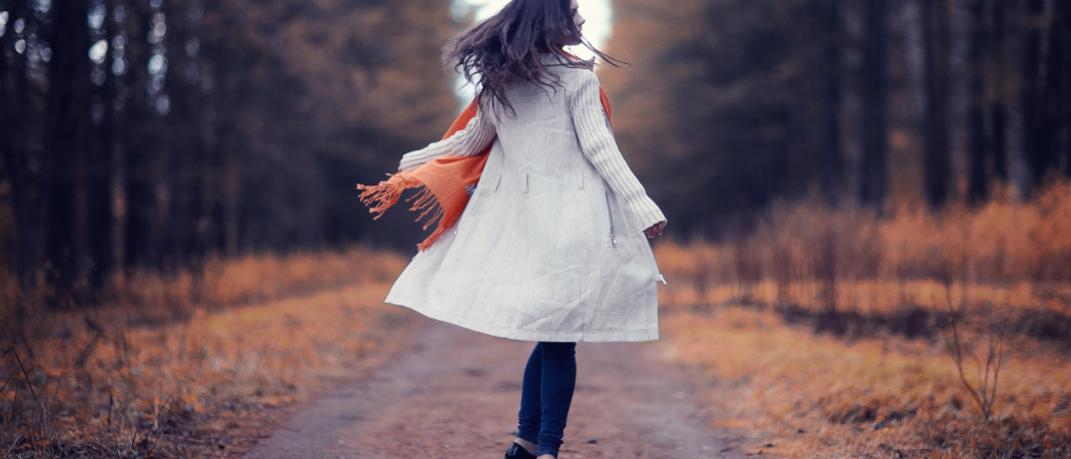 Μια γυναίκα περπατάει χαρούμενη στο πάρκο, Φωτογραφία: Shutterstock