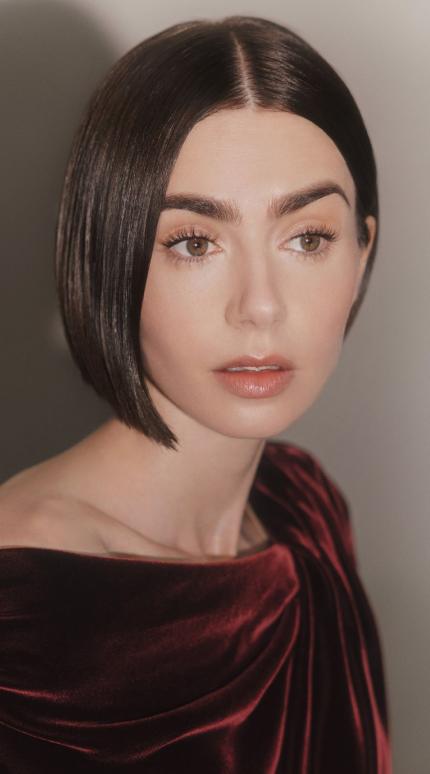 η λίλι κολλινς με μπορντό φόρεμα και καρέ μαλλιά