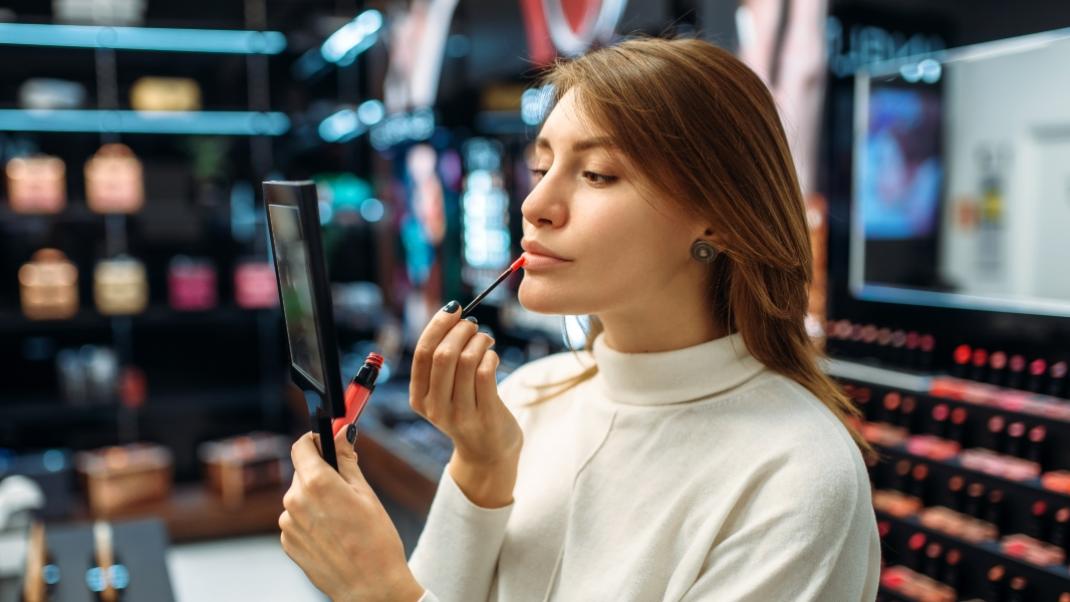 Γυναίκα δοκιμάζει προϊόντα σε κατάστημα ομορφιάς