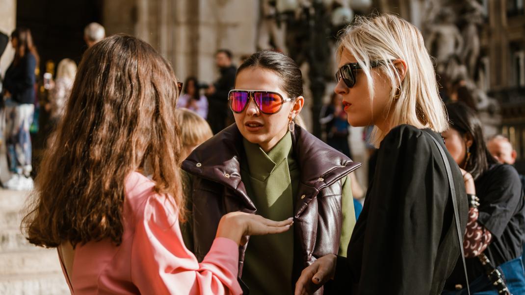 γυναίκες συζητούν με τσάντες και γυαλιά στην εβδομάδα μόδας