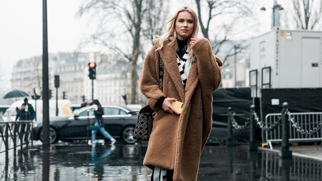 γυναίκα περπατά με παλτό και τσάντα στην εβδομάδα μόδας