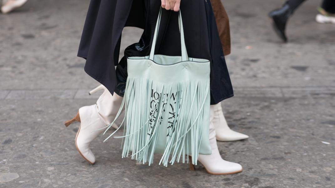 γυναίκες περπατούν με μπότες και τσάντα στην εβδομάδα μόδας