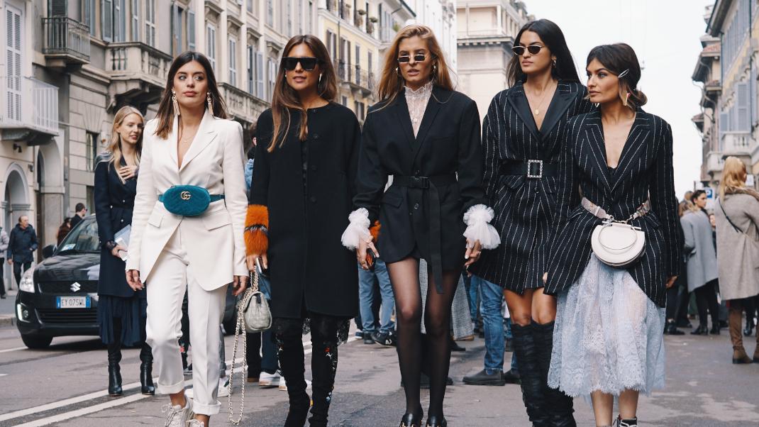 γυναίκες με γυαλιά και μπότες περπατούν στην εβδομάδα μόδας