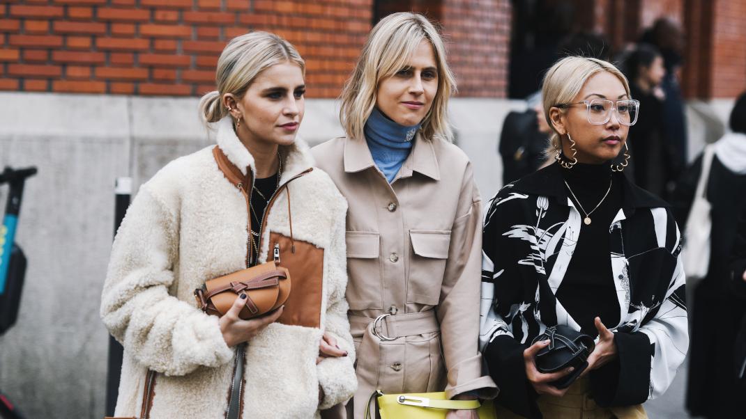 γυναίκες περπατούν με πανωφόρια και πουλόβερ στην εβδομάδα μόδας