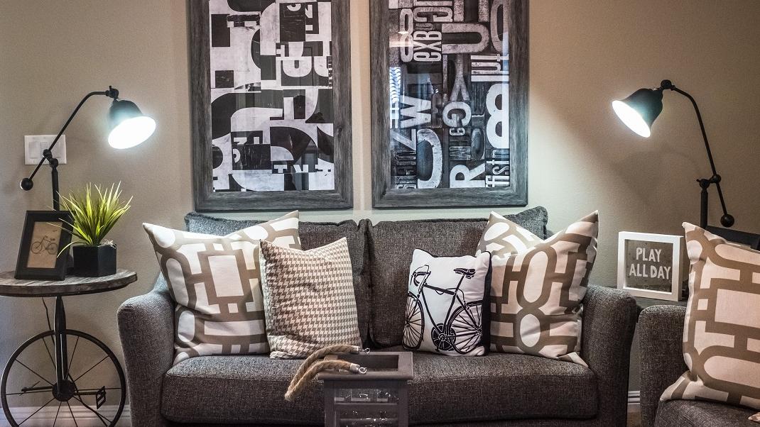 Σαλόνι σε cozy σπίτι με καναπέ, φωτιστικά και πίνακες