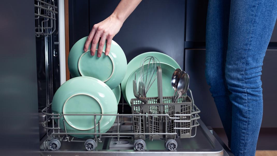 Γυναίκα βάζει πιάτα σε πλυντήριο πιάτων