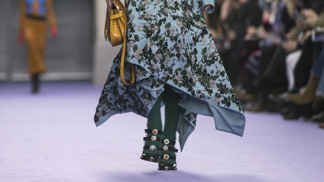 γυναίκα περπατά με πέδιλα και τσάντα σε επίδειξη μόδας