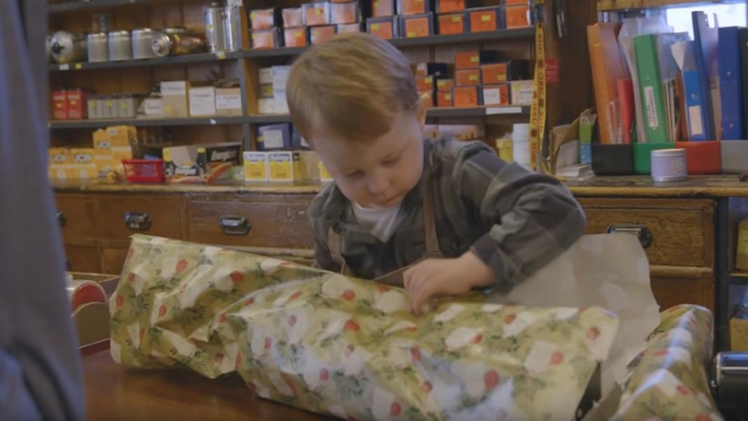 Παιδί τυλίγει δώρα σε χριστουγεννιάτικη διαφήμιση