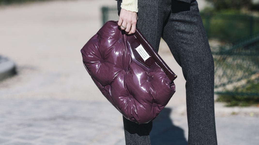 γυναίκα με μωβ καπιτονέ τσάντα στην εβδομάδα μόδας