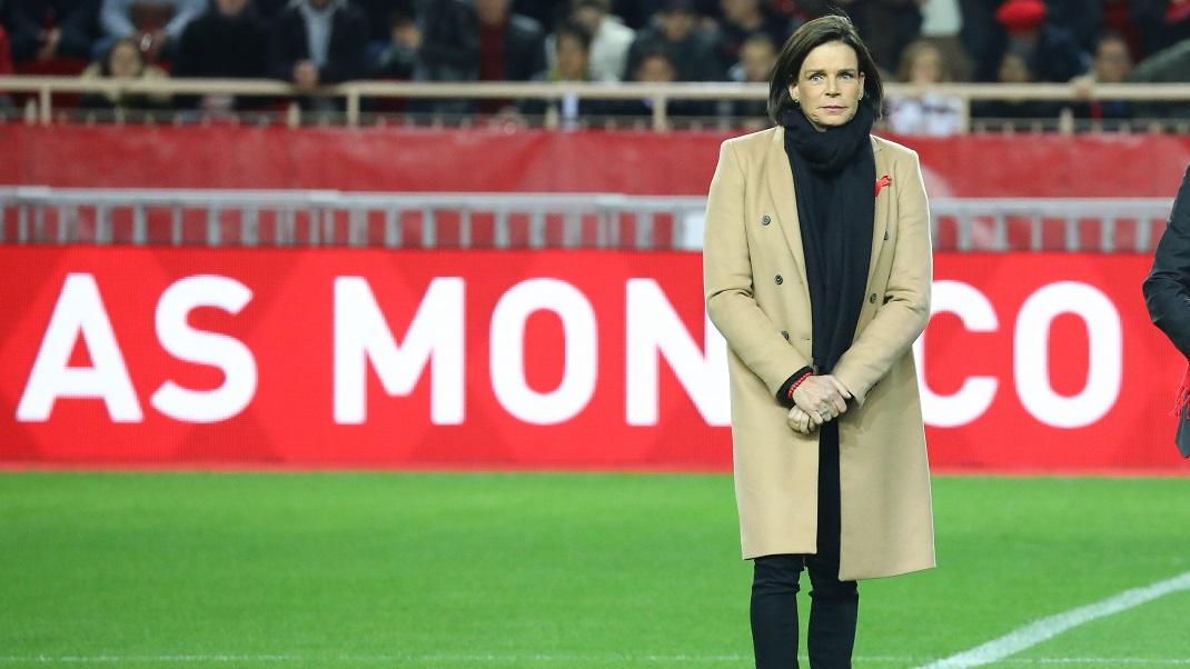 Η πριγκίπισσα Στεφανί του Μονακό με μπεζ παλτό σε γήπεδο ποδοσφαίρου