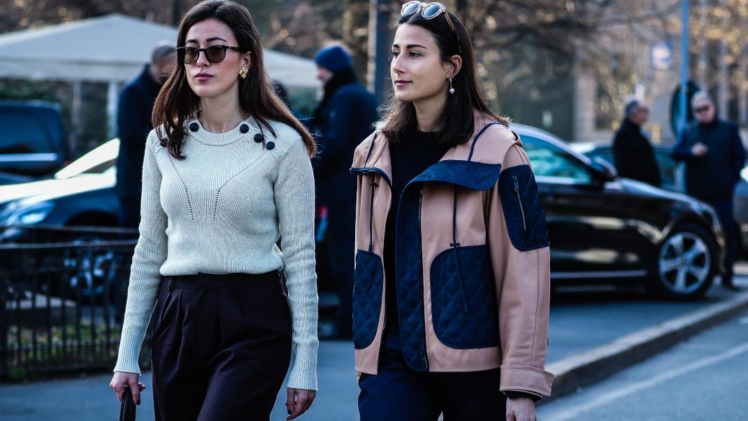 γυναίκες περπατούν με πουλόβερ και μπουφάν στην εβδομάδα μόδας