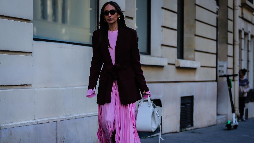 γυναίκα με ροζ φόρεμα και σακάκι περπατά στην εβδομάδα μόδας