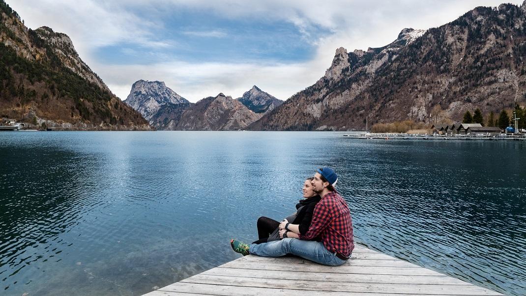 Ζευγάρι αγκαλιά με φόντο βουνά και λίμνη