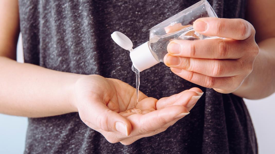 Γυναίκα βάζει στα χέρια της hand sanitizer αντισηπτικό