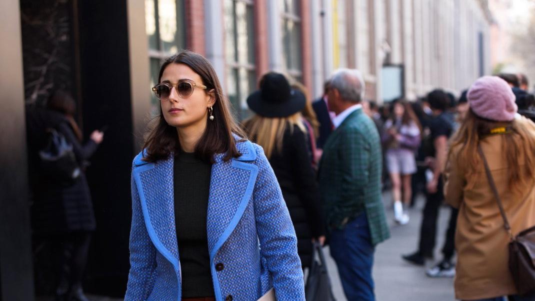 γυναίκα με μπλε παλτό και γυαλιά στην εβδομάδα μόδας